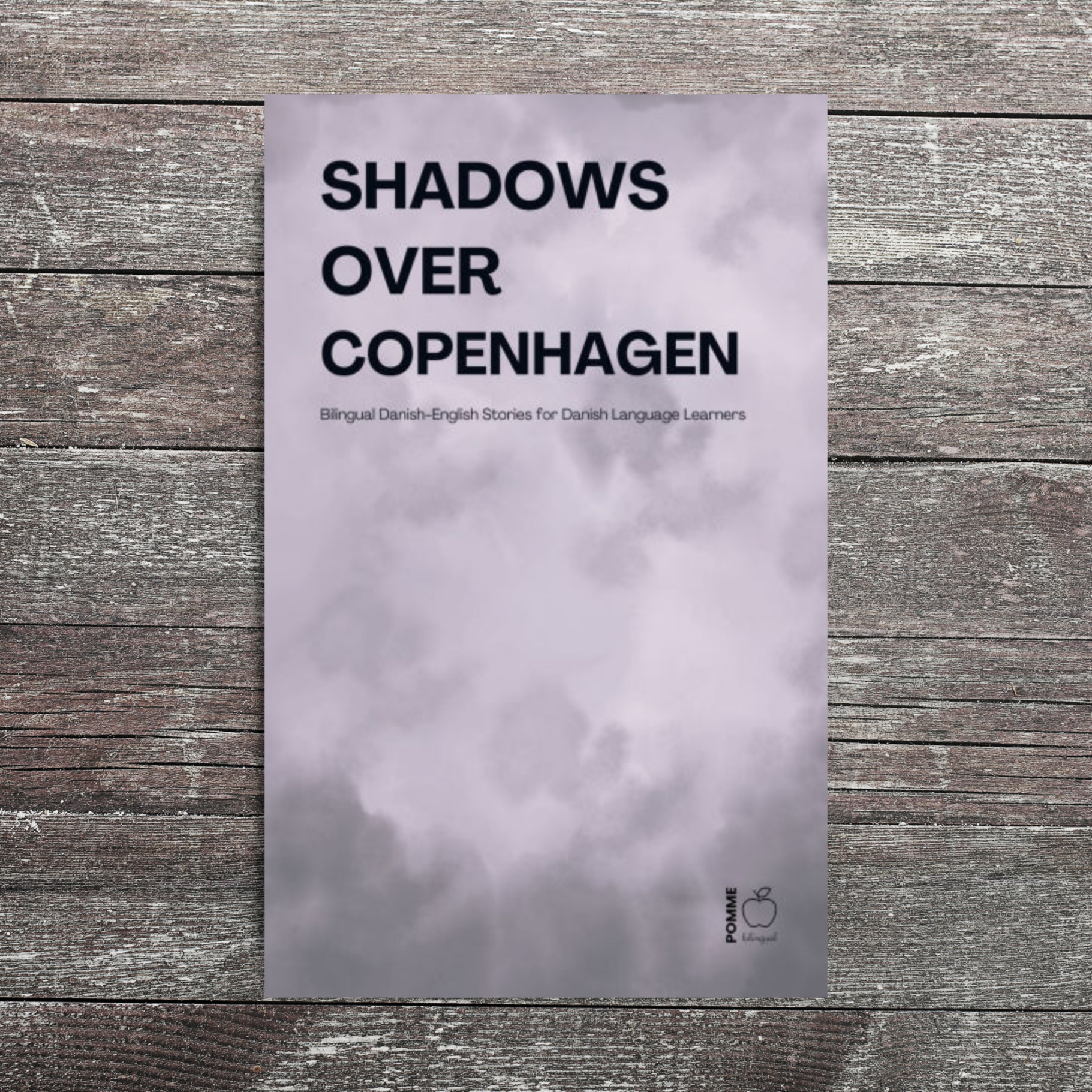 Book cover titled "Shadows Over Copenhagen" against a wooden background.